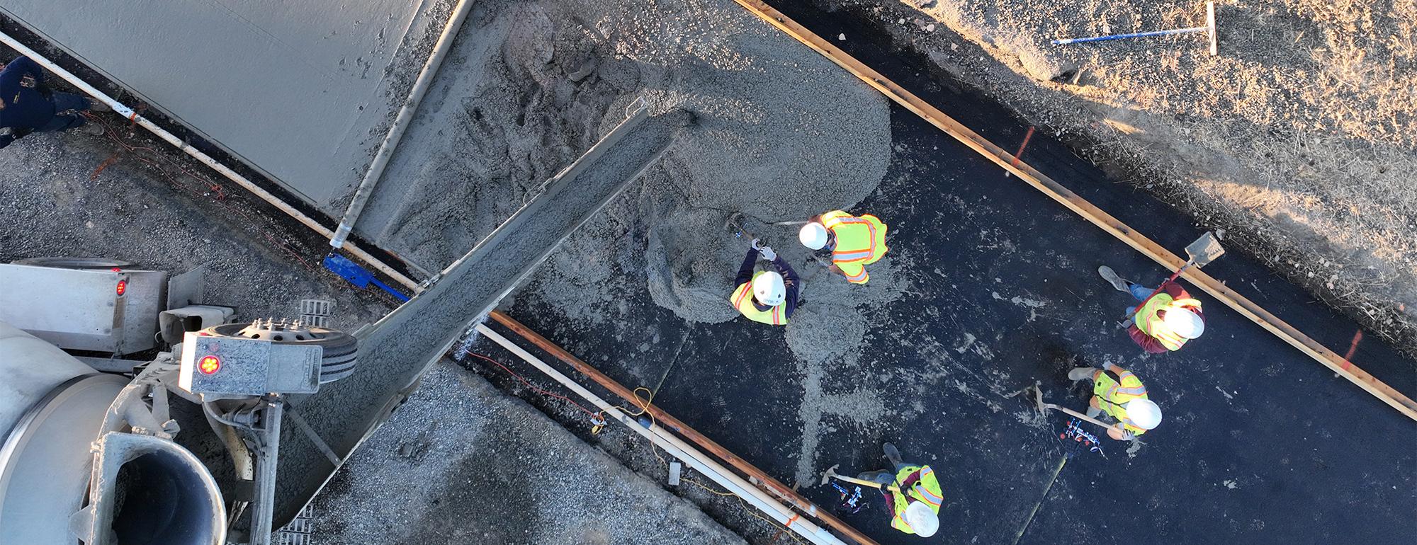 Aerial view of concrete being poured for a new road.