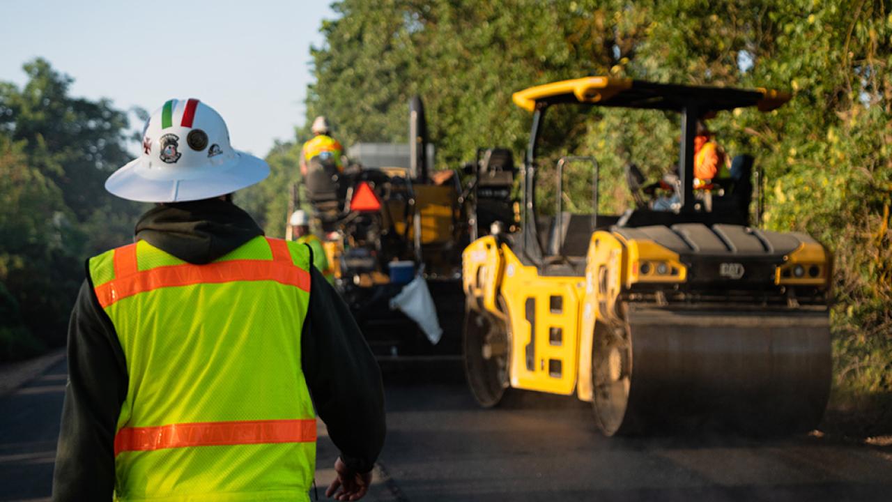 working in PPE and asphalt roller
