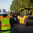 working in PPE and asphalt roller
